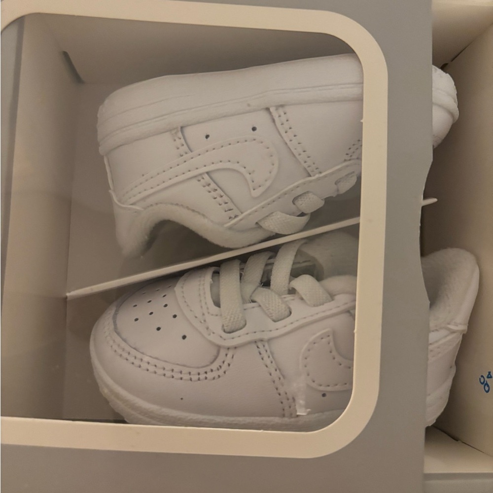 All white infant Nike sneakers